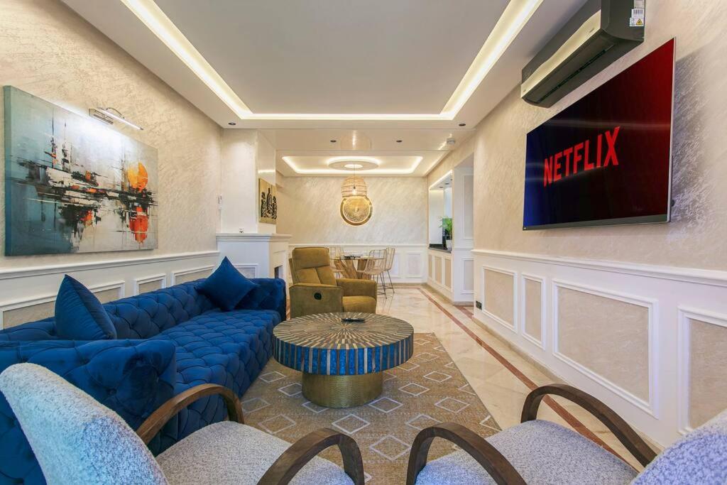 - un hall avec un canapé bleu et une télévision dans l'établissement Luxury Odyssey - Marrakech Centre, à Marrakech