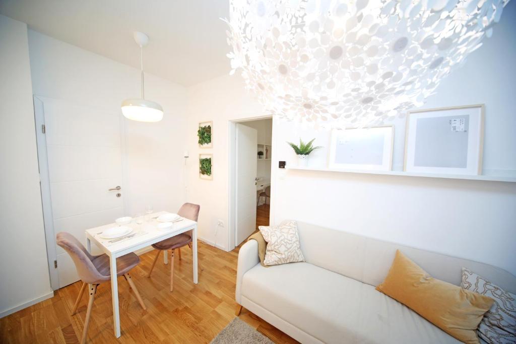 a living room with a white couch and a table at Apartment Fala - self check-in 0-24, fast wi fi, city center in Zagreb