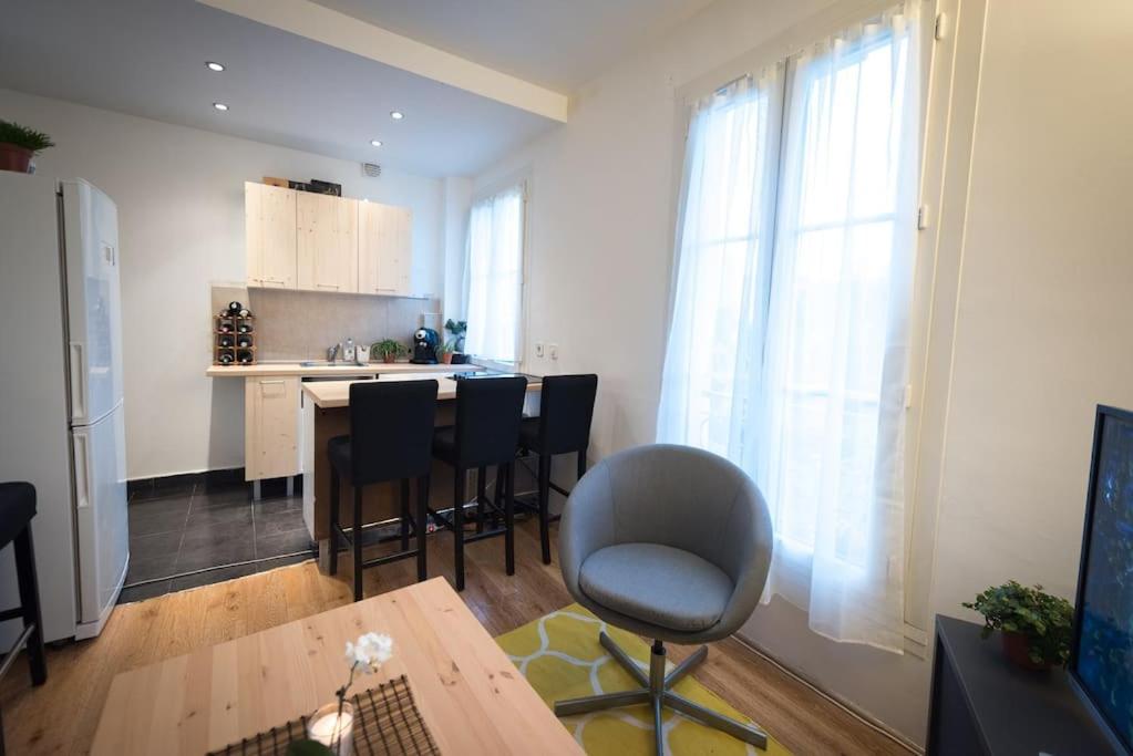 a kitchen with a table and chairs in a room at Contemporary, view of La Défense, all comfort in Puteaux