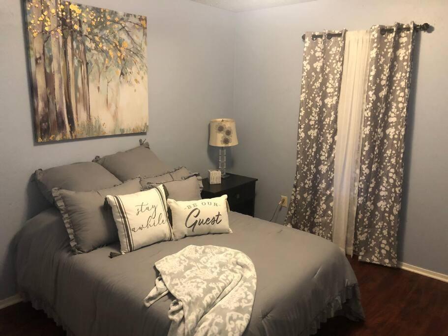 een slaapkamer met een bed met kussens erop bij Charming Home in the Piney Woods of East Texas in Kilgore