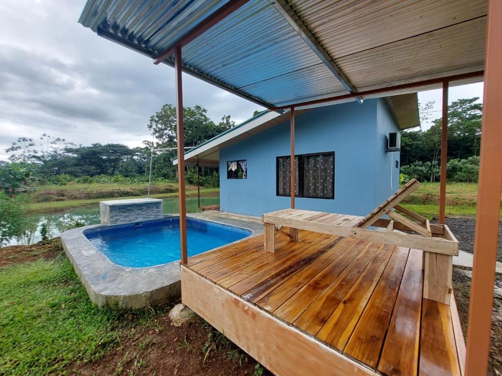 a house with a swimming pool and a wooden deck at Arenal Surá in Fortuna