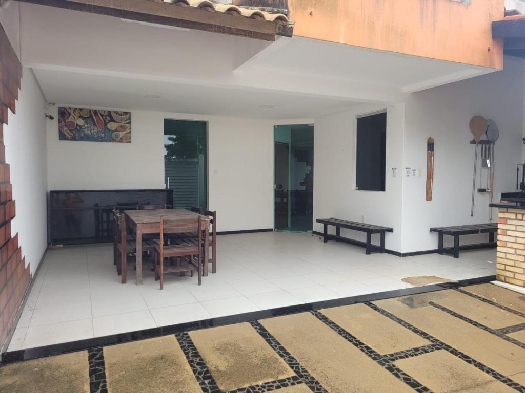 una stanza vuota con tavolo e panche sul pavimento di Casa para temporada - São João 2024 a Campina Grande