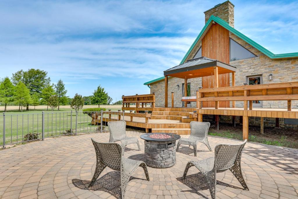 patio z krzesłami i stołem oraz budynek w obiekcie Hornersville Vacation Rental with Private Pond! 