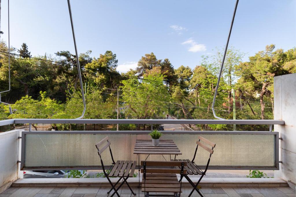 een patio met 2 stoelen en een tafel op een balkon bij Pangrati Gardens Apartment by Athenian Keys in Athene