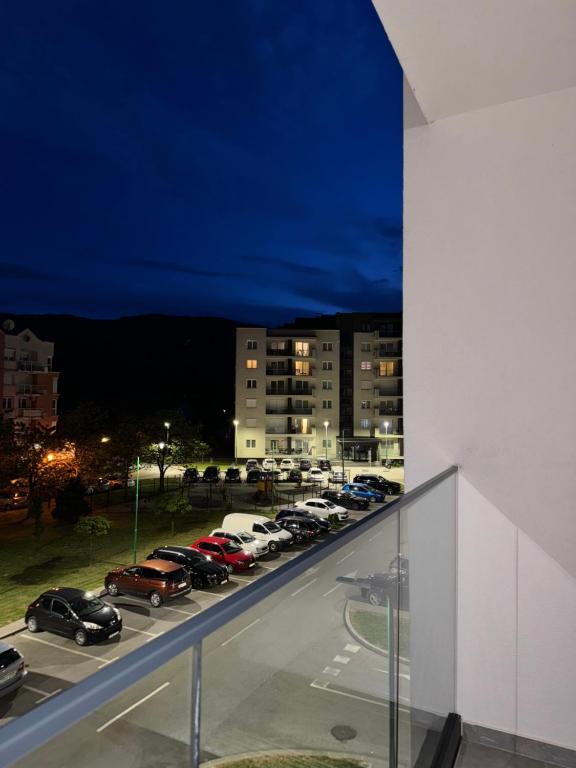 uma vista para um parque de estacionamento à noite com carros estacionados em Sarajevo Apartment Magnolia em Sarajevo