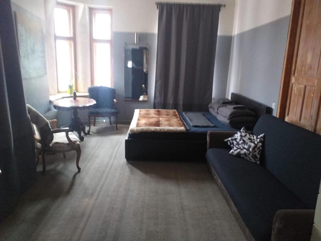ein Wohnzimmer mit einem Sofa und einem Tisch in der Unterkunft Boutique Hostel Cesis-X in Cēsis