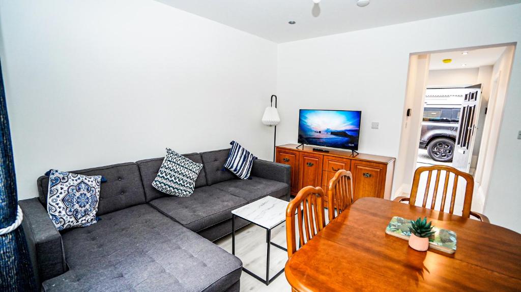 ein Wohnzimmer mit einem Sofa und einem Tisch in der Unterkunft 4-Bedroom, 3-Bath Home Sleeps 8 Free Parking in Farnham Royal