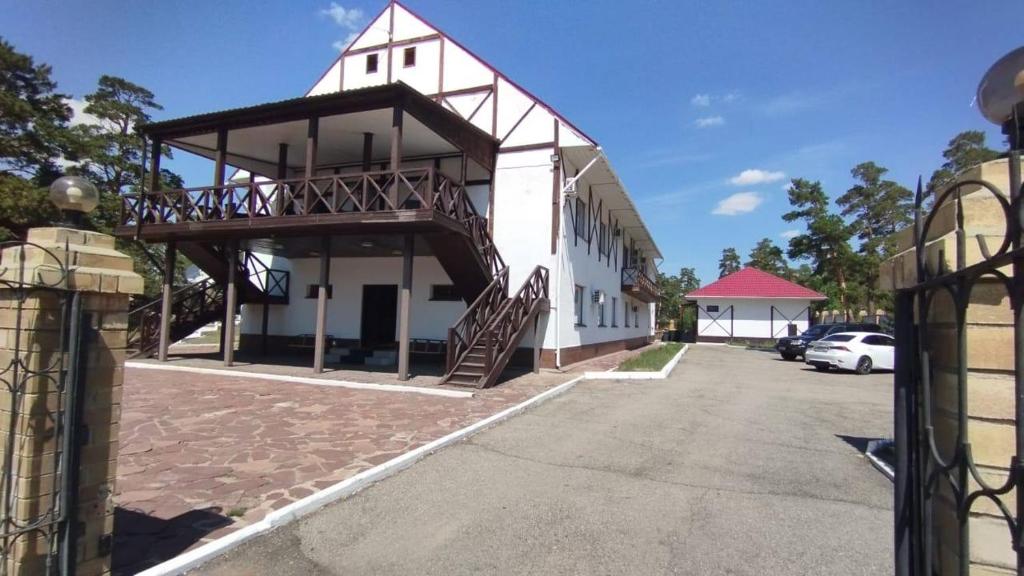 Goluboy Zaliv في بوروفوي: مبنى أبيض كبير مع درج على الجانب