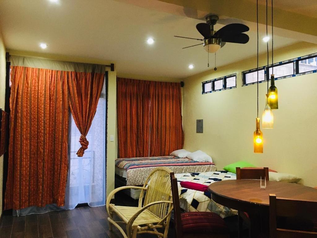 uma sala com um quarto com uma mesa e uma cama em Apartamento Jacob em San Pedro La Laguna