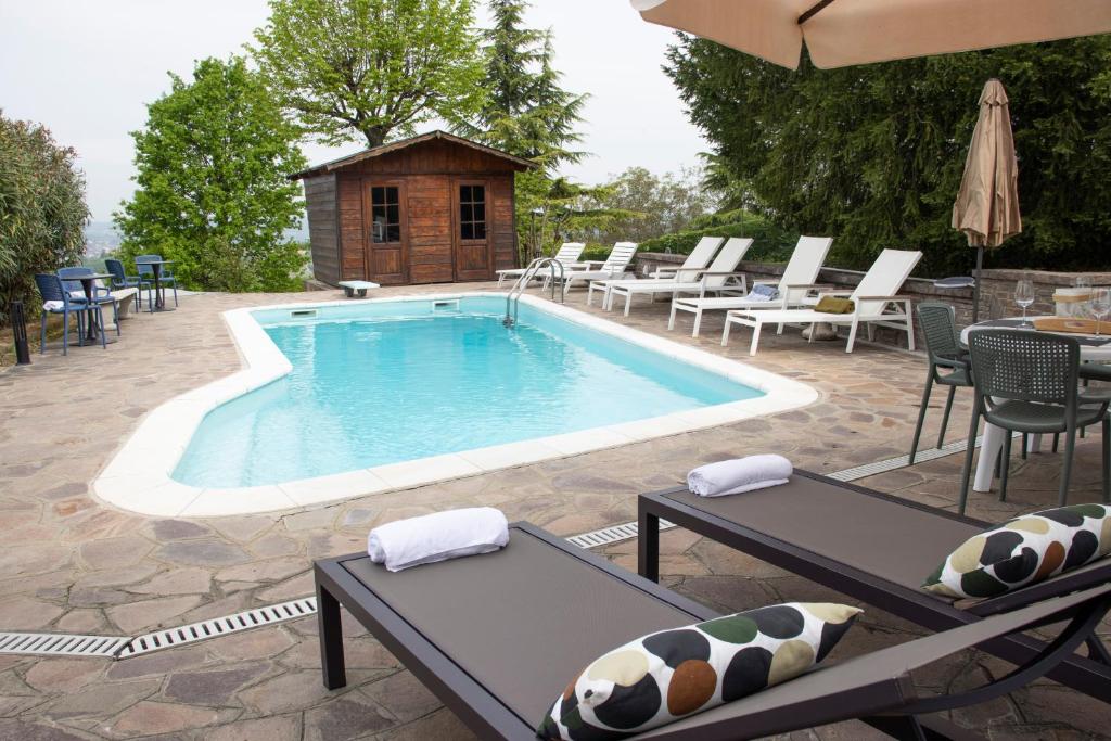 einen großen Pool mit Stühlen und einem Tisch in der Unterkunft Villa Magna with pool Alba Hills in Govone