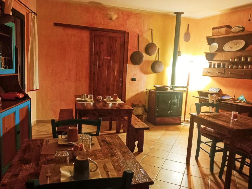 a kitchen with wooden tables and a stove at Locanda D'Ogliastra, in Triei