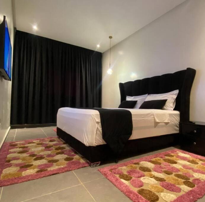 - une chambre avec un grand lit et un tapis dans l'établissement Impérial appartement 3BR, à Harhoura