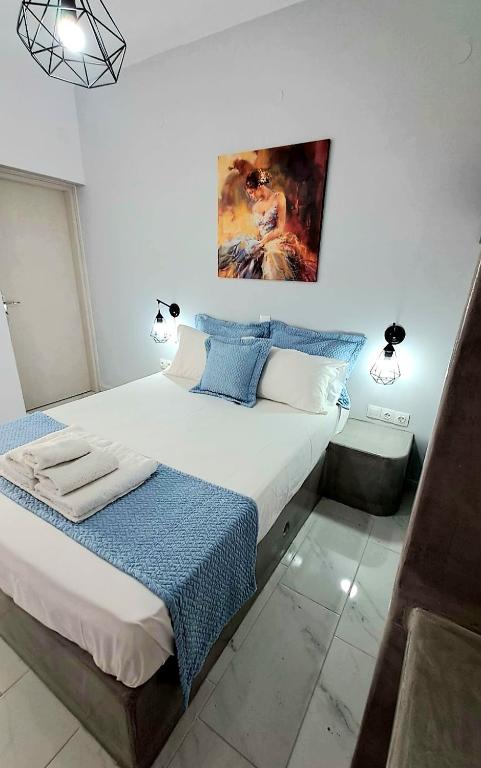 a bedroom with a bed and a painting on the wall at Lava Guesthouse Prive in Karterados