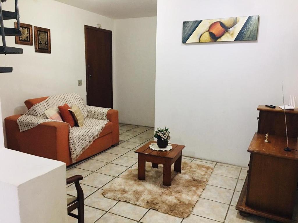 een woonkamer met een bank en een salontafel bij Apto Duplex confortável a apenas 2 km do Capivari in Campos do Jordão