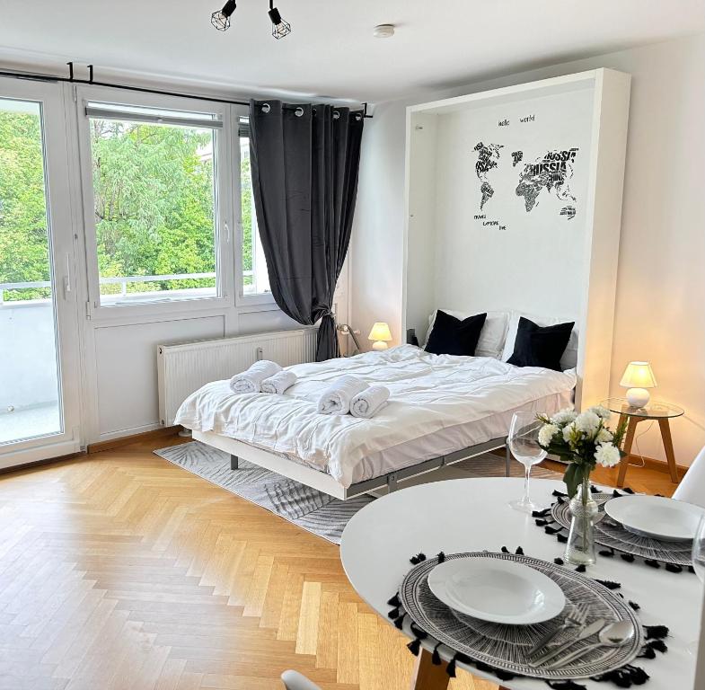 a white bedroom with a bed and a table at Stilvolles Apartment - Unteraching in Unterhaching