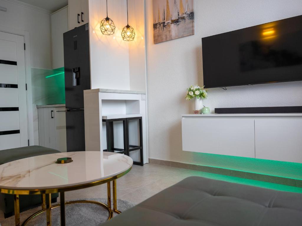 Bileća的住宿－Aurora studio - Bileca，客厅配有桌子和电视