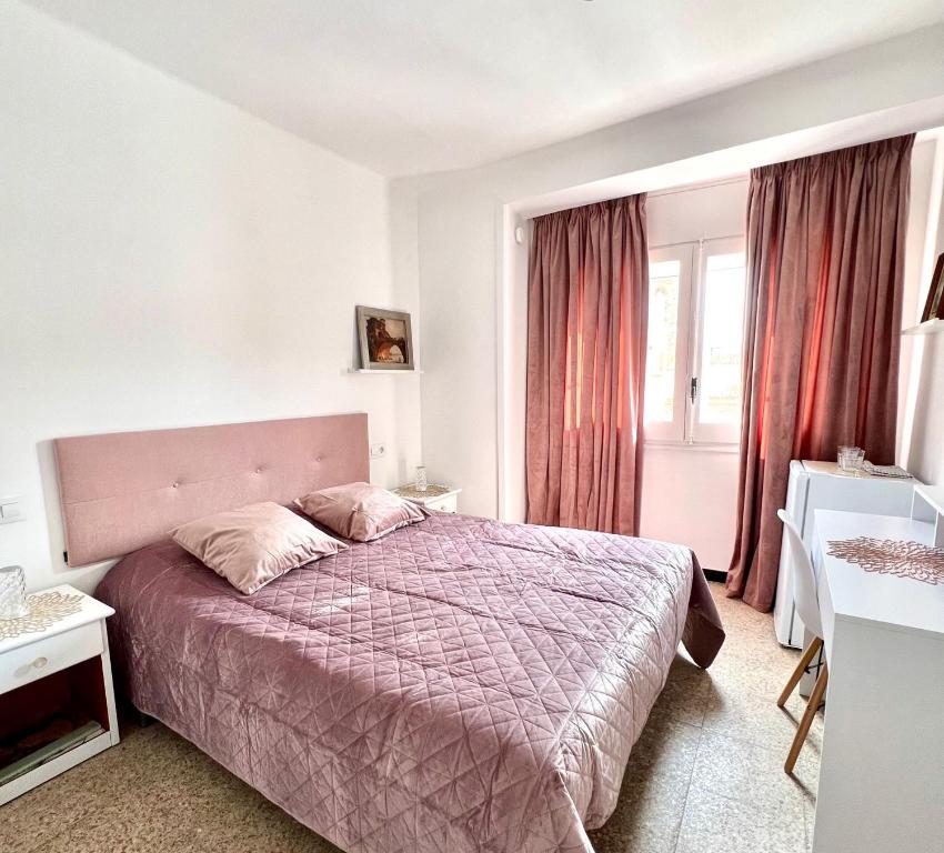 um quarto com uma cama com uma colcha roxa em Escondite central con terraza compartida en la azotea em Roses