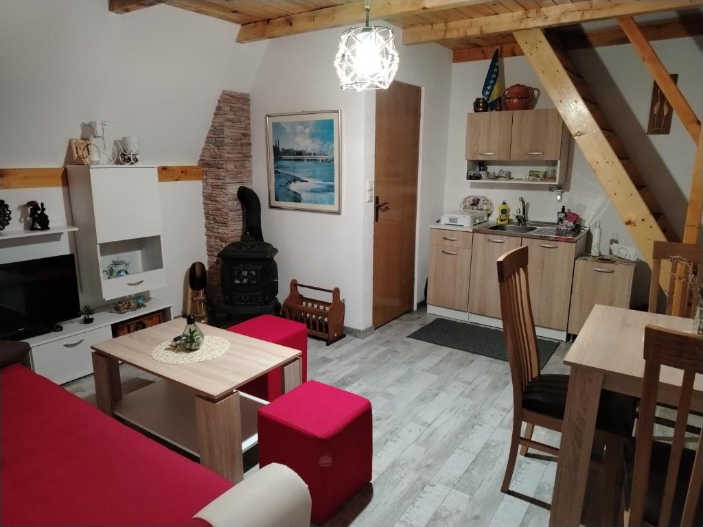 uma sala de estar com um sofá, uma mesa e uma cozinha em Vikendica Raj em Bihać