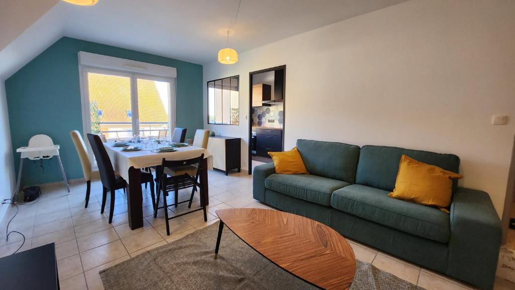 a living room with a green couch and a table at Le clos des Boucaniers in Berck-sur-Mer