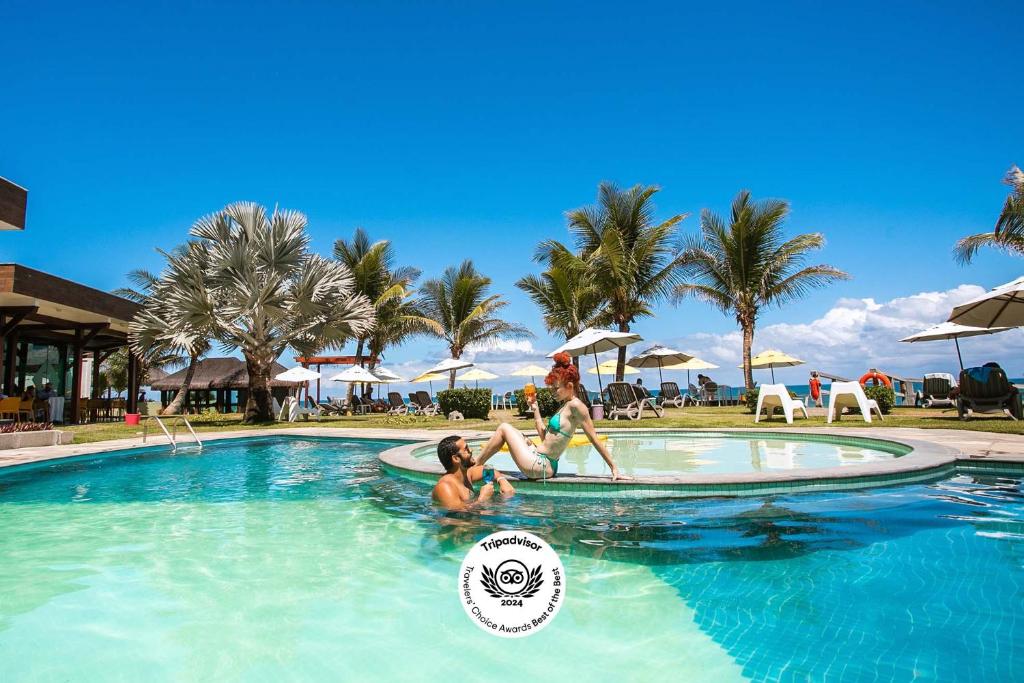 dos personas en una piscina en un complejo en Kembali Hotel Porto de Galinhas - Adults Only, en Porto de Galinhas