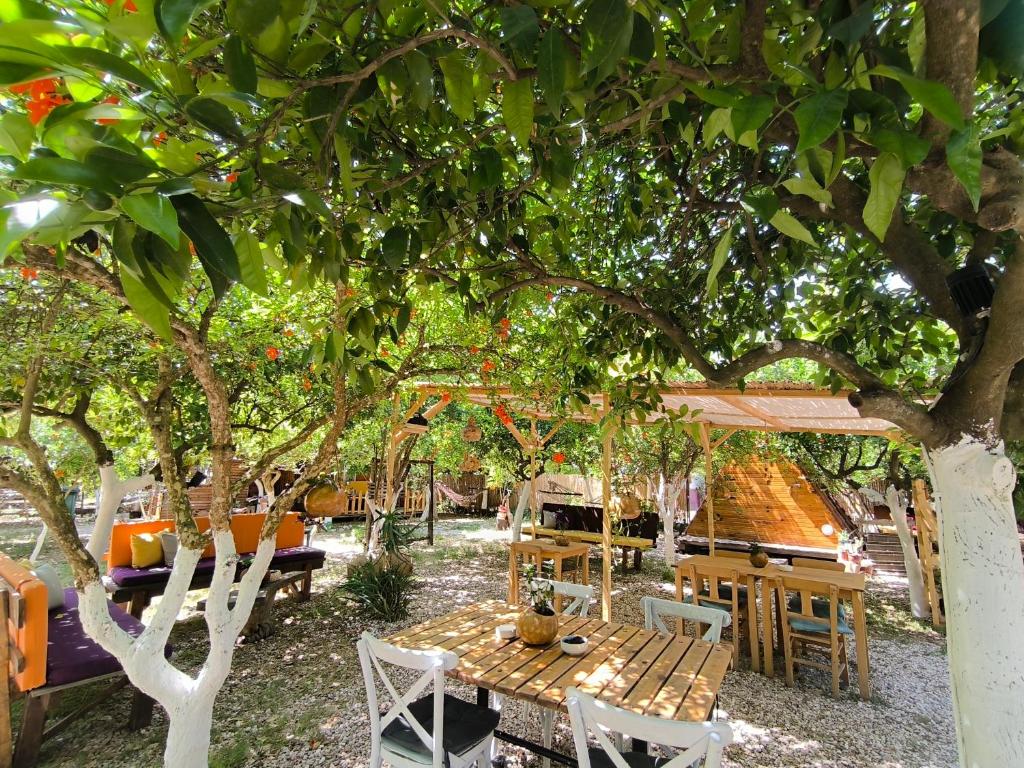 a wooden table and chairs under a tree at Litost Cafe Bungalow in Adrasan