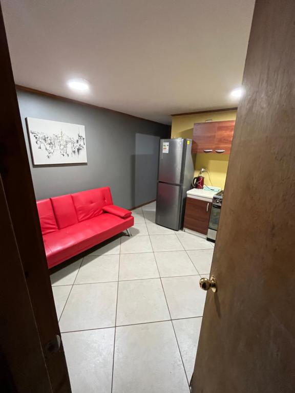 un soggiorno con divano rosso e frigorifero di Cabañas Francia a Osorno