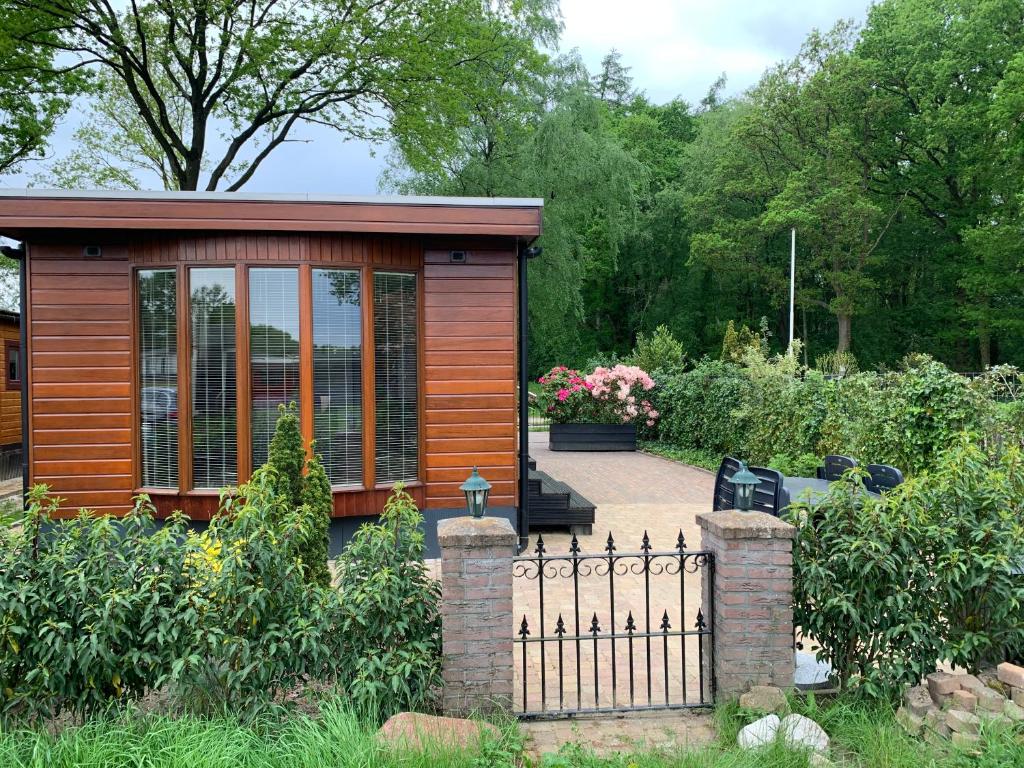 ein kleines Haus mit einem Zaun im Garten in der Unterkunft De Specht in Anloo