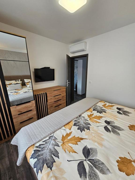 a bedroom with a bed with a leaf blanket at Apartman Daria in Bibinje