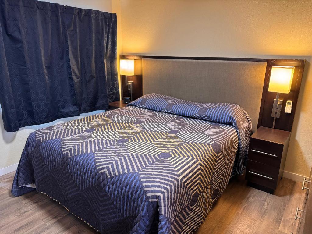 a bedroom with a bed with a blue and white comforter at The Lodge Tulelake in Tulelake
