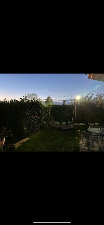 une vue d'une cour arrière avec une balançoire et une aire de jeux dans l'établissement Appartement jacuzzi, à Pontault-Combault