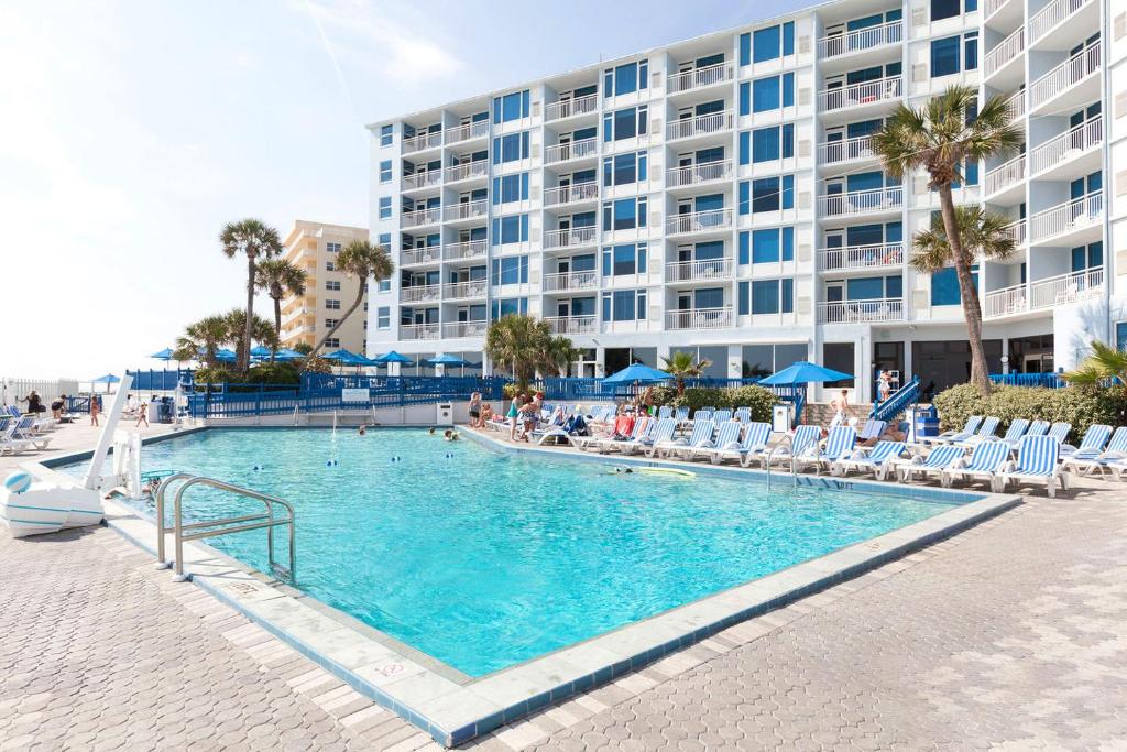 a swimming pool in front of a large building at Islander Beach Resort by CV in New Smyrna Beach