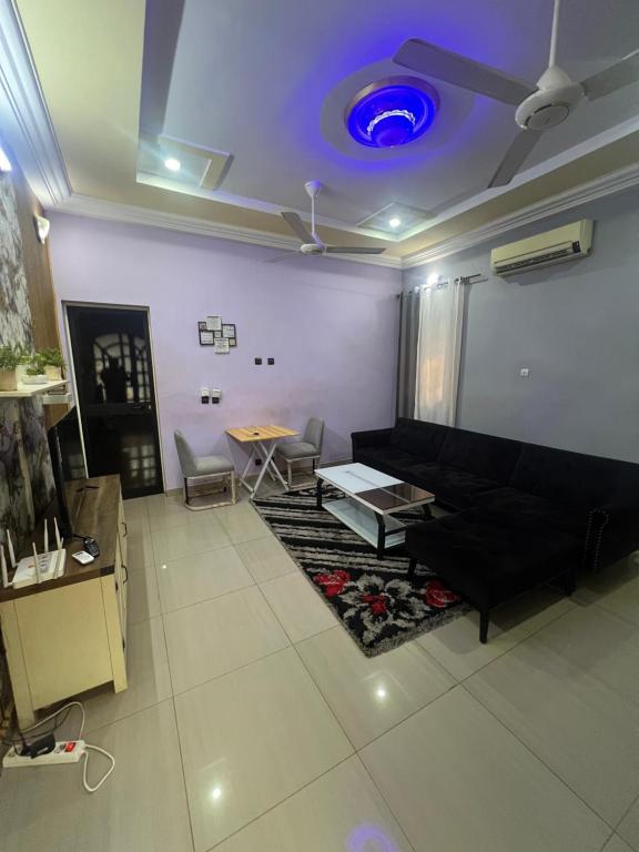 ein Wohnzimmer mit einem Sofa und einer blauen Decke in der Unterkunft Villa JFK2 in Ouagadougou