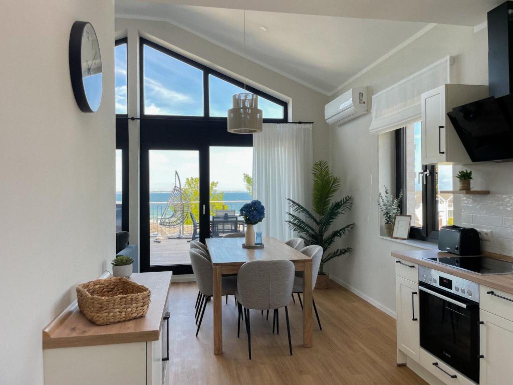 a kitchen and dining room with a table and a view of the ocean at My Baltic Sea - Ferienwohnungen im Ocean Hill in Scharbeutz