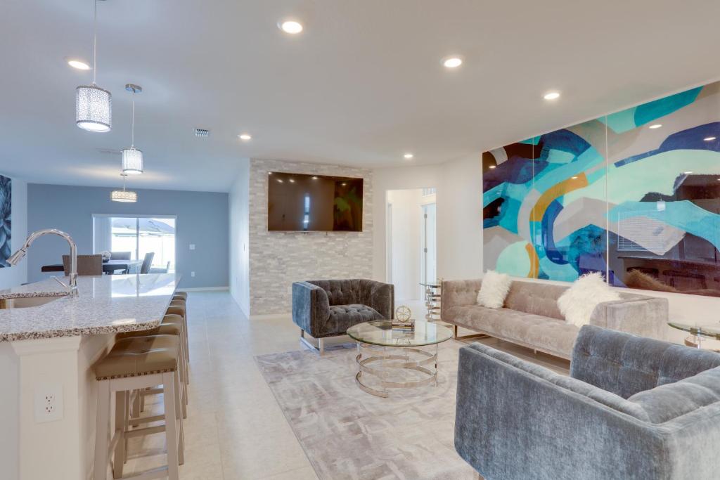 a living room with a couch and a kitchen at 6 Mi to River Park Marina, Boardwalk Home with Pool in Port Saint Lucie