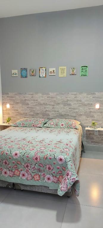 ein Schlafzimmer mit einem Bett mit einer Blumendecke in der Unterkunft Casarosegolds in Uberlândia