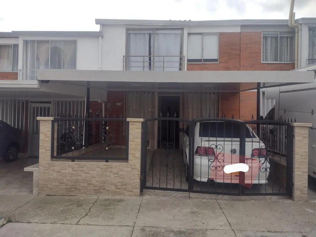 un portail en face d'une maison avec une clôture dans l'établissement Espectacular casa vacacional con garaje en Pereira, à Pereira