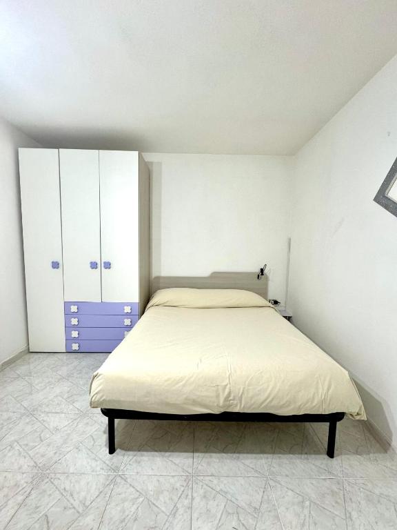 Schlafzimmer mit einem Bett, weißen Wänden und Fliesenböden in der Unterkunft Monolocale Romeo in Locri