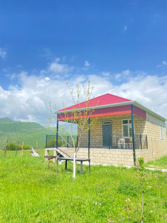 a small building with a bench in a field at Şamaxı Cennetbagı Evi in Şamaxı