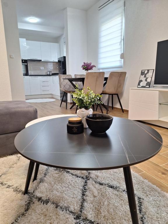 a living room with a coffee table and a kitchen at Apartman WIN Sokobanja in Soko Banja