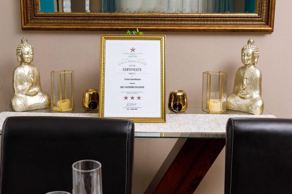 a table with gold statues on it with a framed diploma at Toriso Hotels Group in Nelspruit