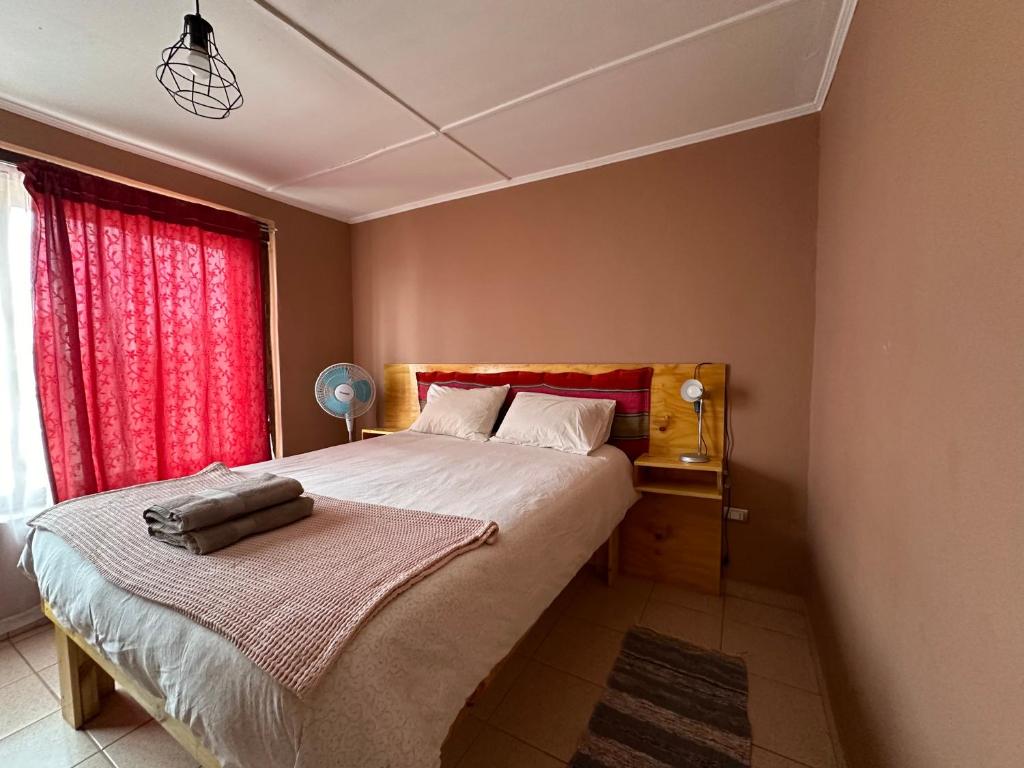 a bedroom with a large bed with a red window at Casa Once in San Pedro de Atacama