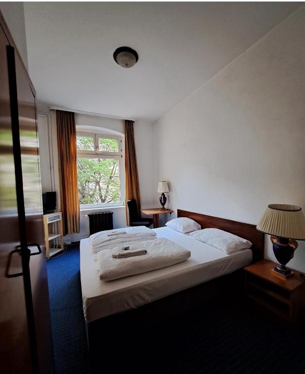 ein Hotelzimmer mit zwei Betten und einem Fenster in der Unterkunft Märkischer Hof Hotel in Berlin