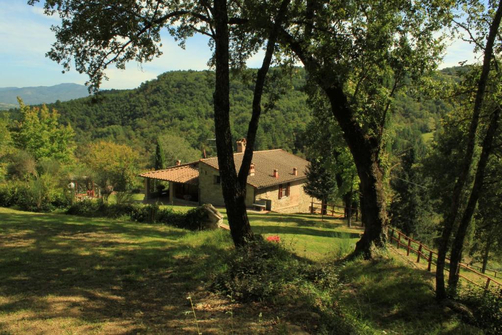 una casa in mezzo a un campo con alberi di Relax in Tuscany a Poppi