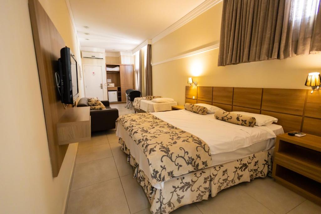 um quarto de hotel com duas camas e uma televisão de ecrã plano em Wynn Batel em Curitiba