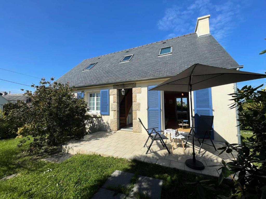 une maison avec un parasol et des chaises sur une terrasse dans l'établissement Résidence L98-perros Guirec - Maison avec jardin, proche de Trestraou MAE-8521, à Perros-Guirec