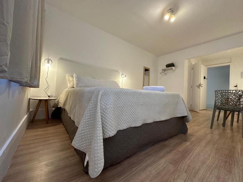 Un dormitorio con una cama con una manta blanca. en Maravilha, en Río de Janeiro
