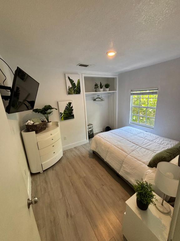 1 dormitorio con 1 cama, vestidor y TV en Queen bedroom in best Location! - Private Parking, Laundry and Drop Off Lugagge, en Miami