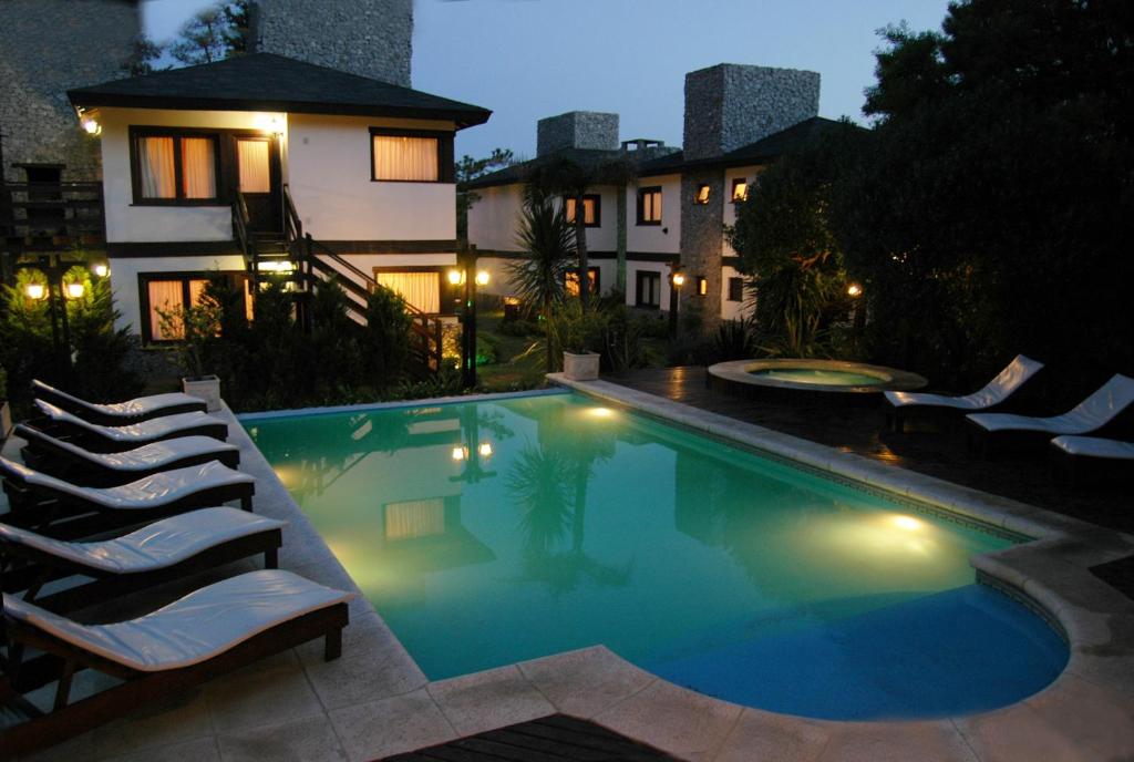 una piscina con tumbonas junto a una casa en Careyes Villa de Mar & Spa en Mar de las Pampas