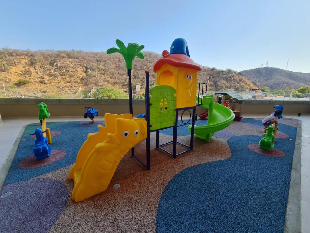 um playground com muitos tipos diferentes de equipamentos de jogo em Apartamento cerca a la Playa em Gaira