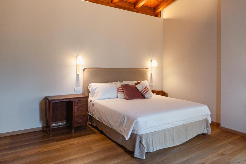 a bedroom with a bed with a nightstand and two lamps at Agriturismo La Costa in Gropparello